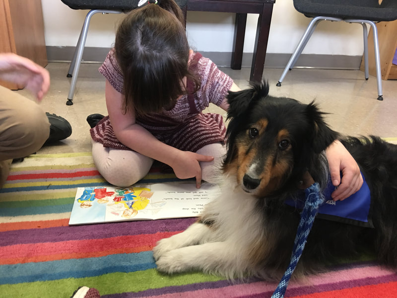 Kida the therapy dog visiting with children